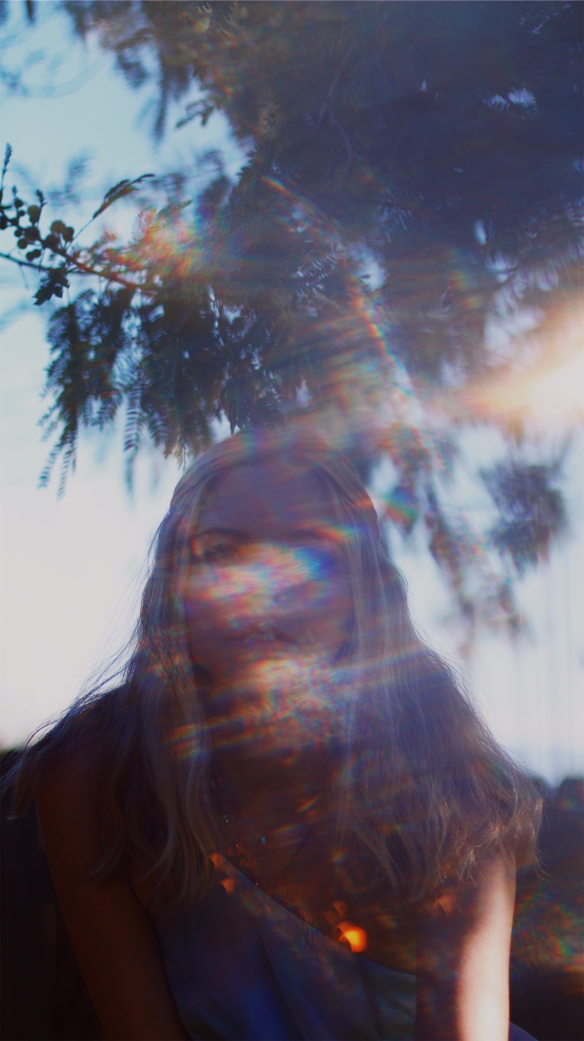 Close up self portrait with the sun blurred in the lense