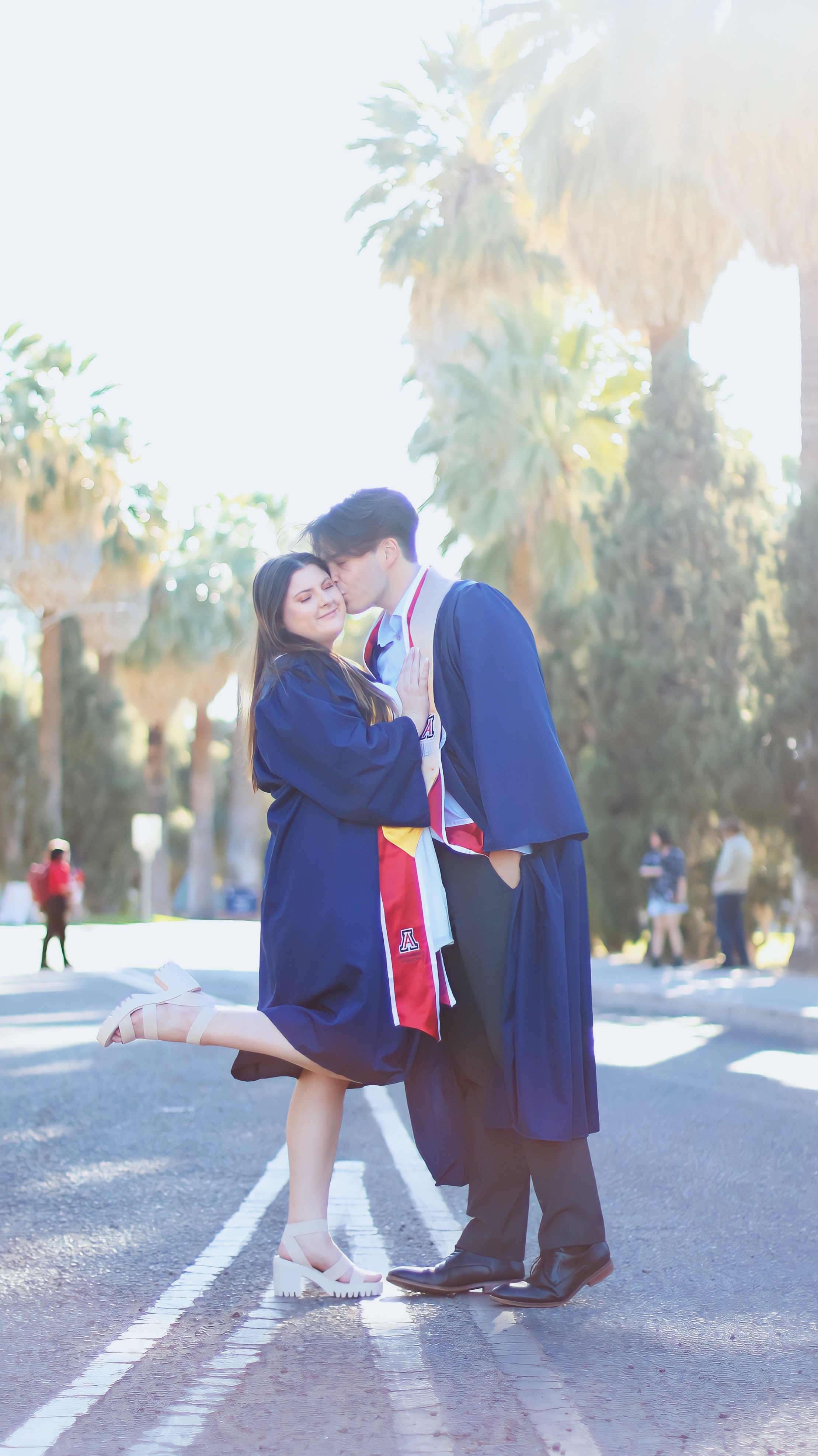 A couple graduating together while embracing in front of the camera