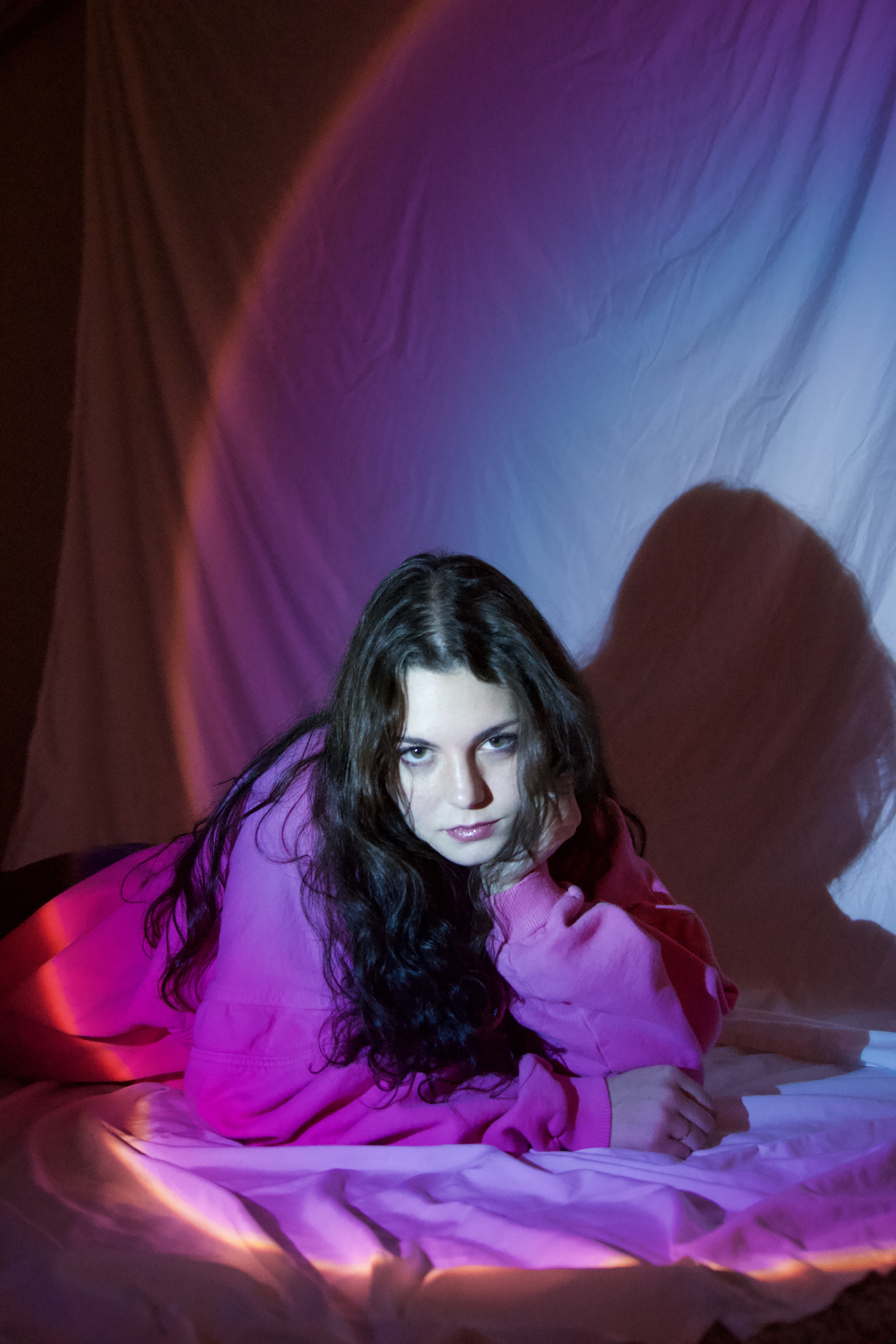 Young woman wearing pink with dramatic lighting