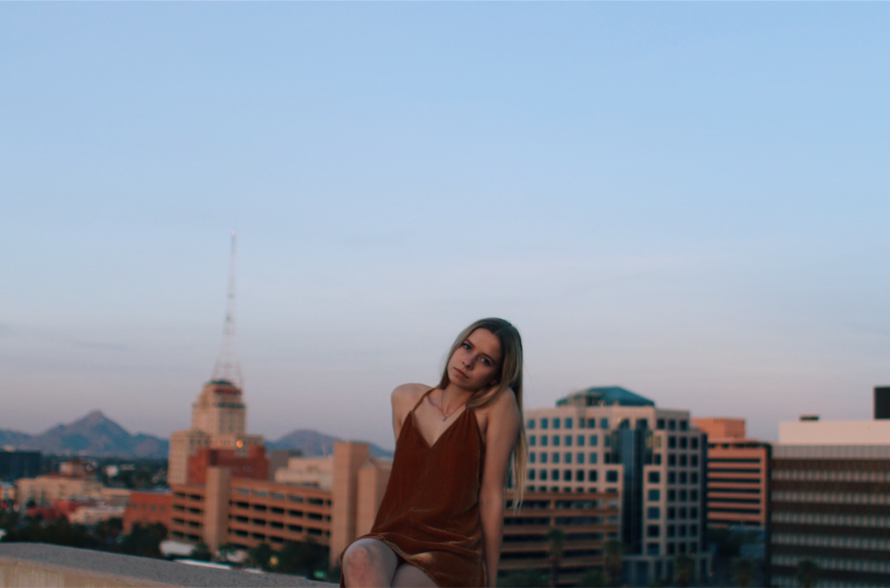 Young women posing in a red dress on the top of a building 1