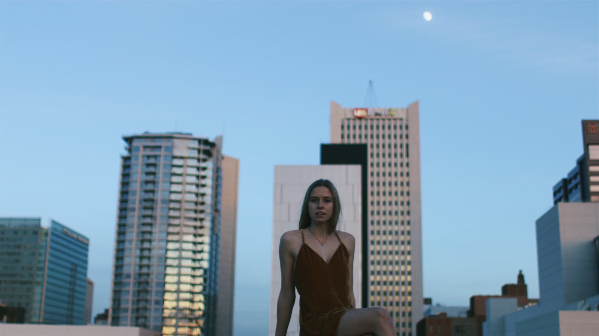 Young women posing in a red dress on the top of a building 2