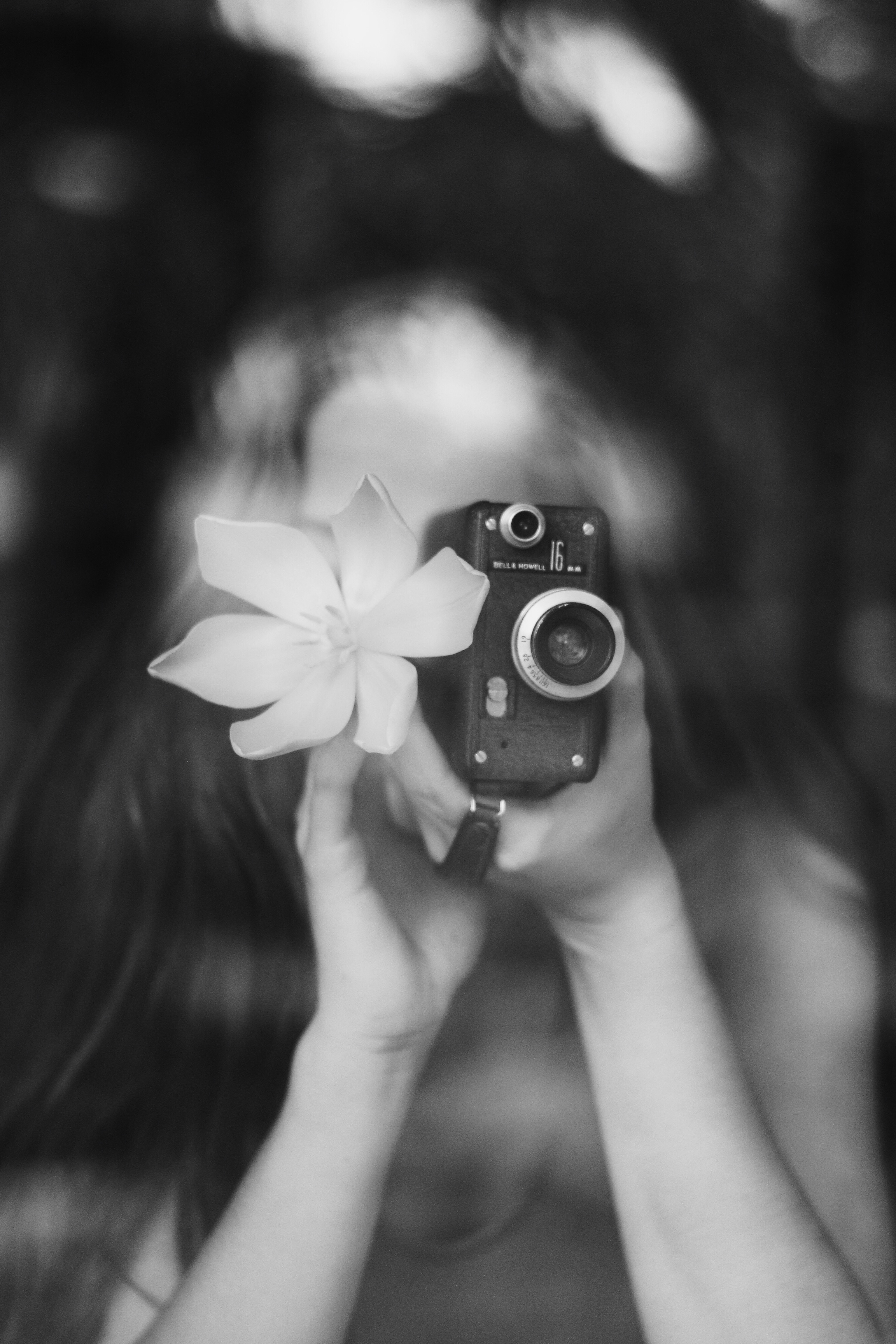 black and white close up of a women taking a photo on a vintage camera