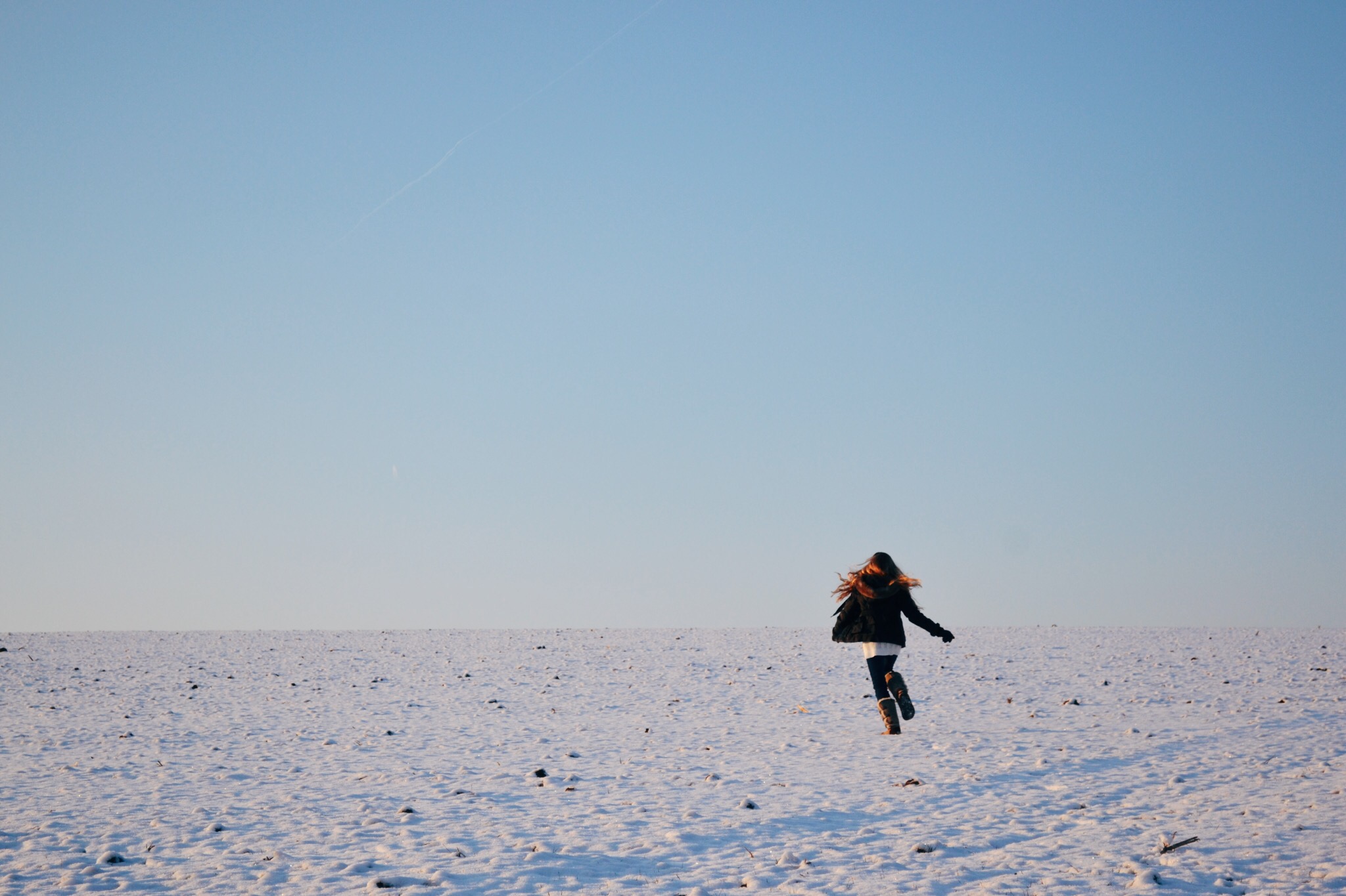 Young women running away in the snow