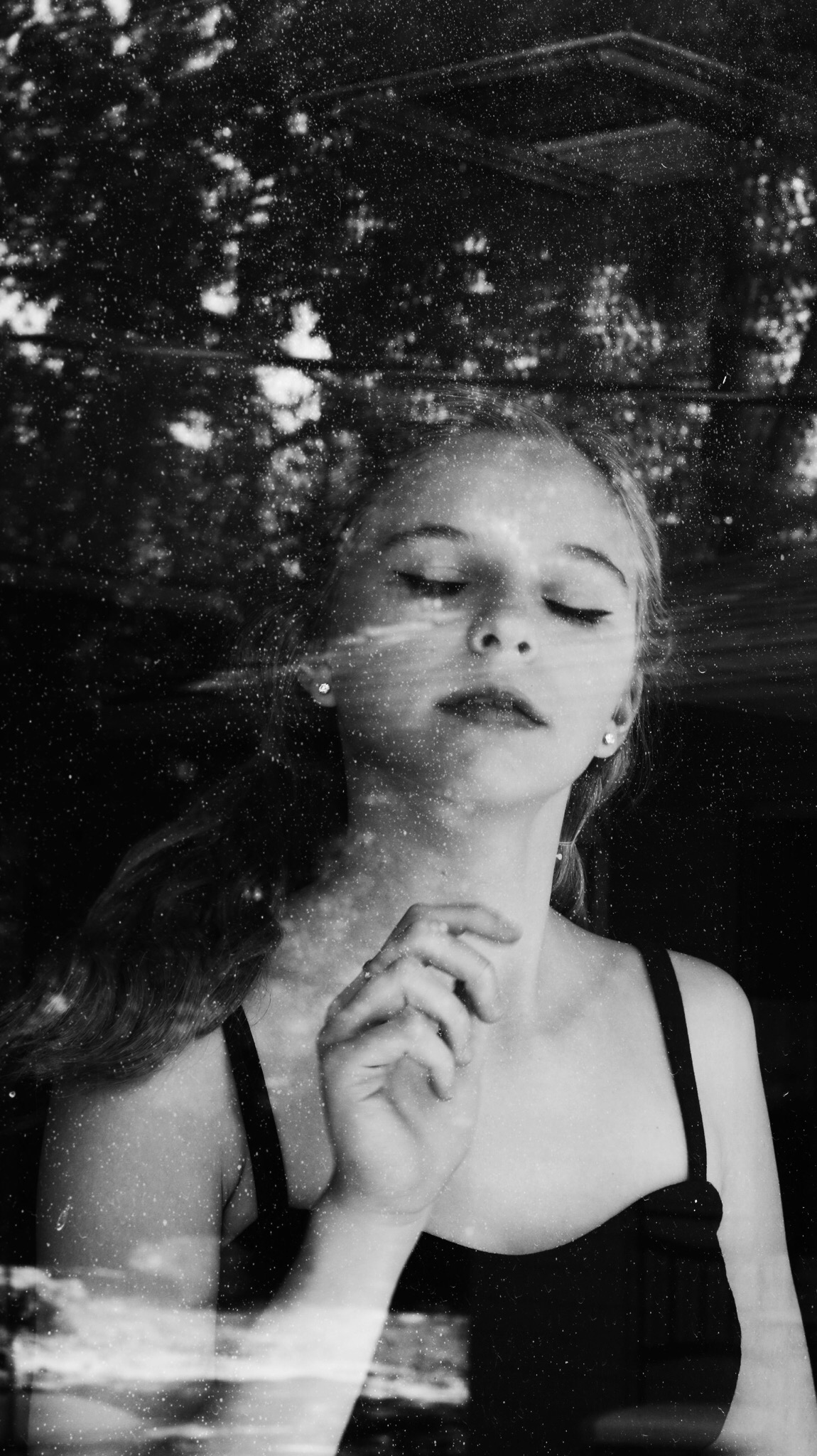 Young women in black white smelling a flower in the air