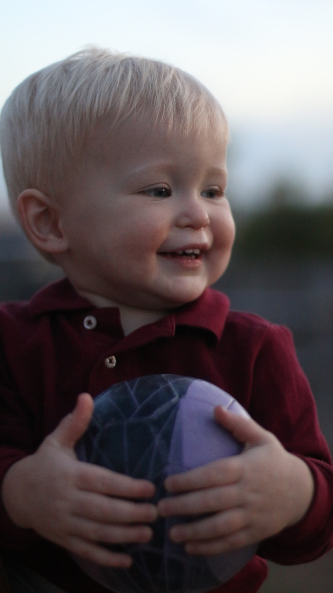 Close up of baby boy with blonde hair and a red dress shirt